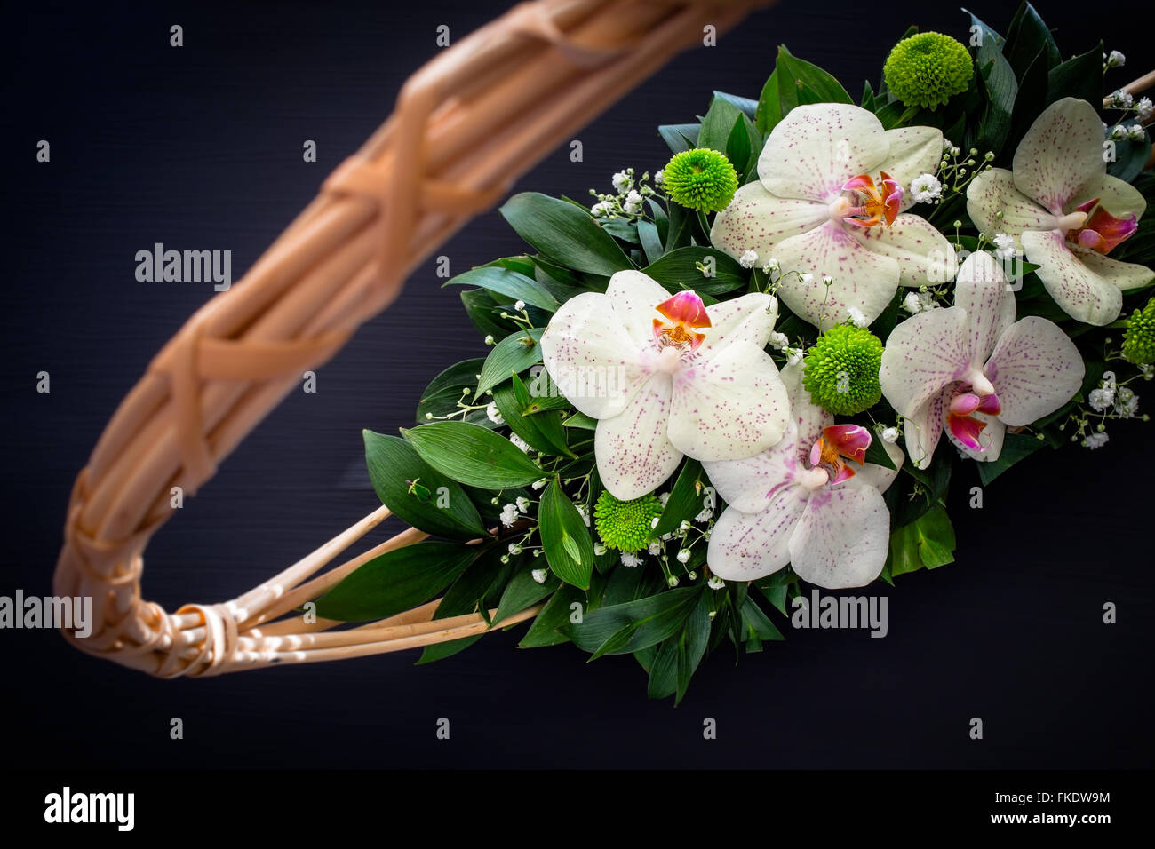 Las orquídeas arreglo floral en canasta Fotografía de stock - Alamy