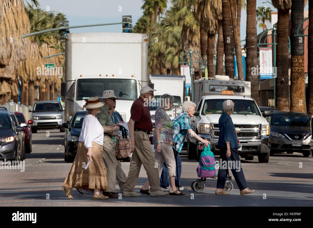 Los ciudadanos senior de cruzar una calle muy transitada, Palm Springs, California, EE.UU. Foto de stock