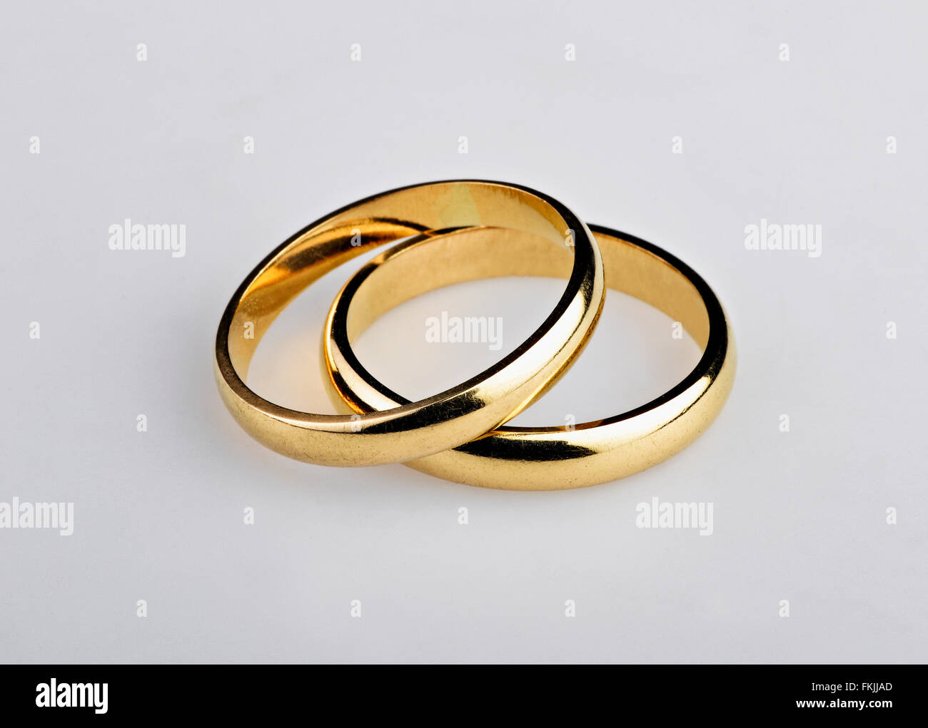 Utiliza dos anillos boda de oro sobre fondo gris Fotografía de stock - Alamy