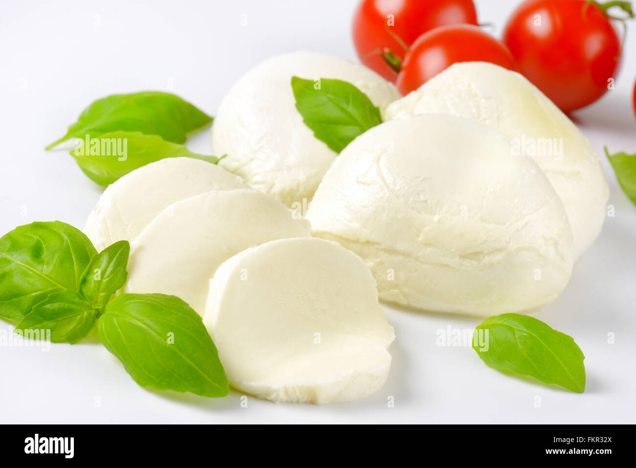 Detalle de mozzarella, tomates cherry y albahaca fresca - Ingredientes para ensalada Caprese Foto de stock