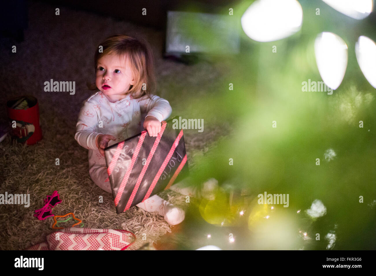 Chica caucásica abriendo regalo de Navidad Foto de stock