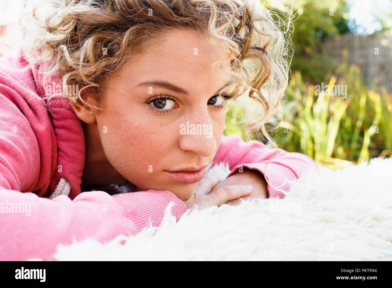 Mujer joven con las manos en la barbilla mirando a la cámara Foto de stock