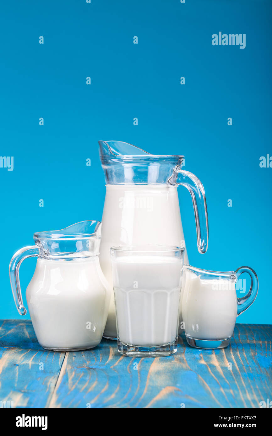 La leche fresca natural sobre fondo azul. Foto de stock