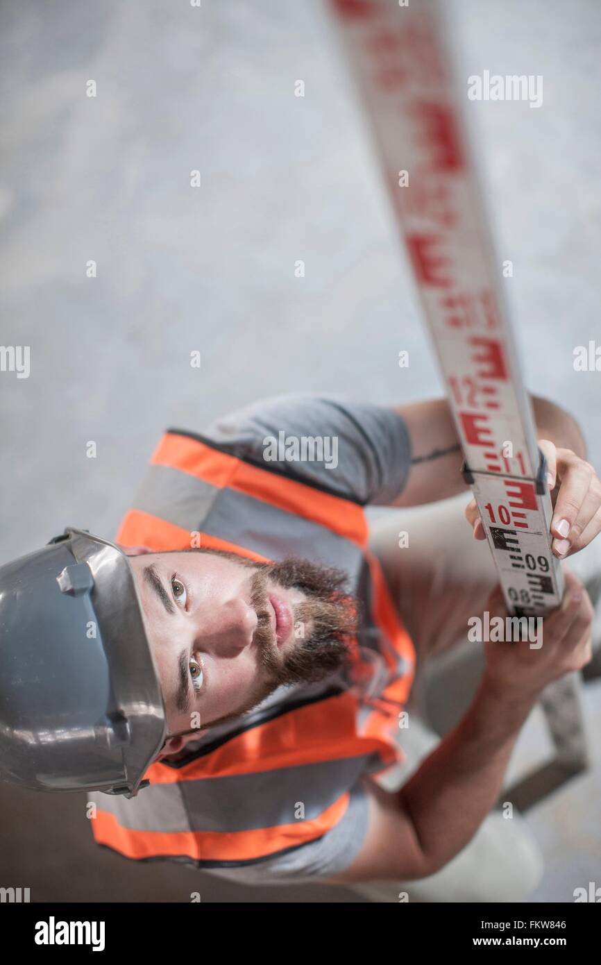 Un alto ángulo de visualización de los jóvenes varones builder con regla de medición Foto de stock