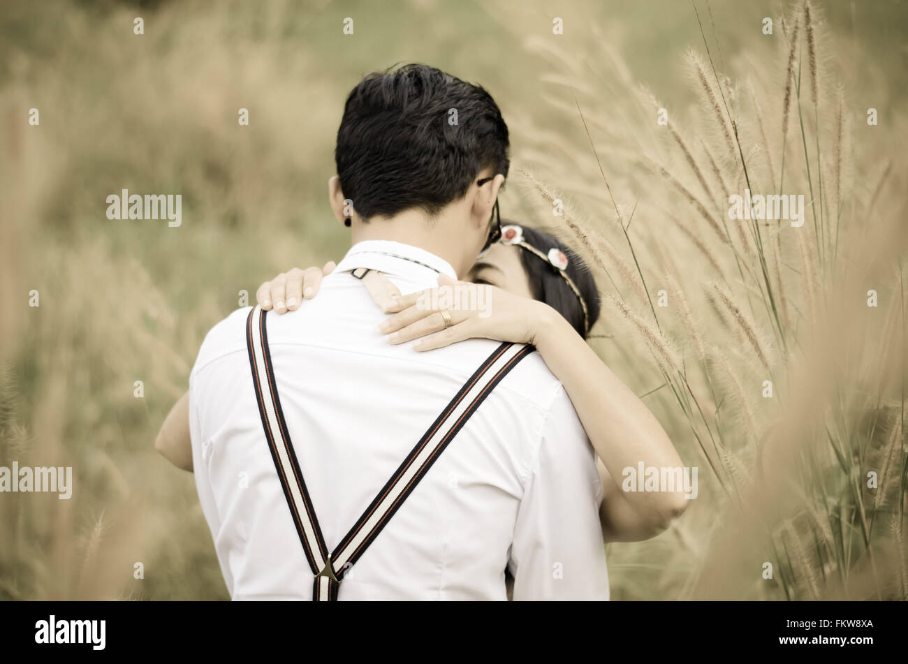 Pareja beso y abrazo en campo de hierba Foto de stock