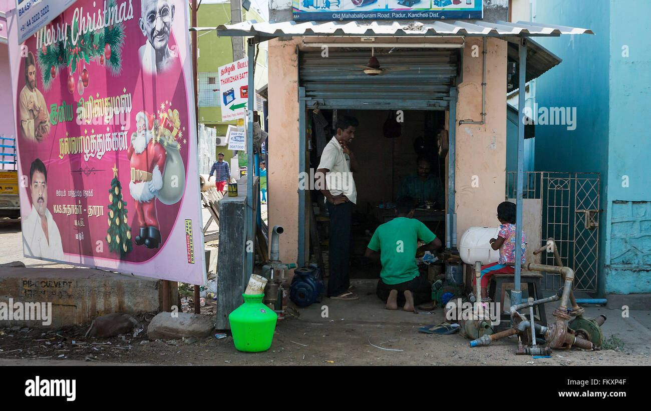 Las personas reparando bombas en un taller de reparaciones en la carretera a lo largo de la Old Mahabalipuram Road, cerca de Chennai, India Foto de stock