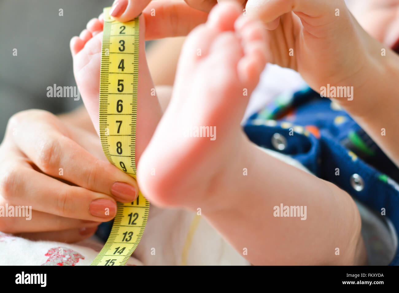 Madre diminuto bebé de medición con un medidor de pie Fotografía de stock -  Alamy