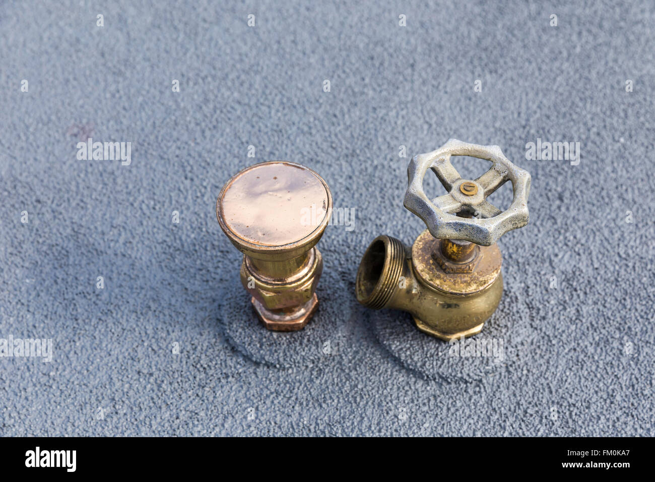 Fontanería tuberías de cobre con una sola válvula sobre una superficie de fondo de metal gris Foto de stock