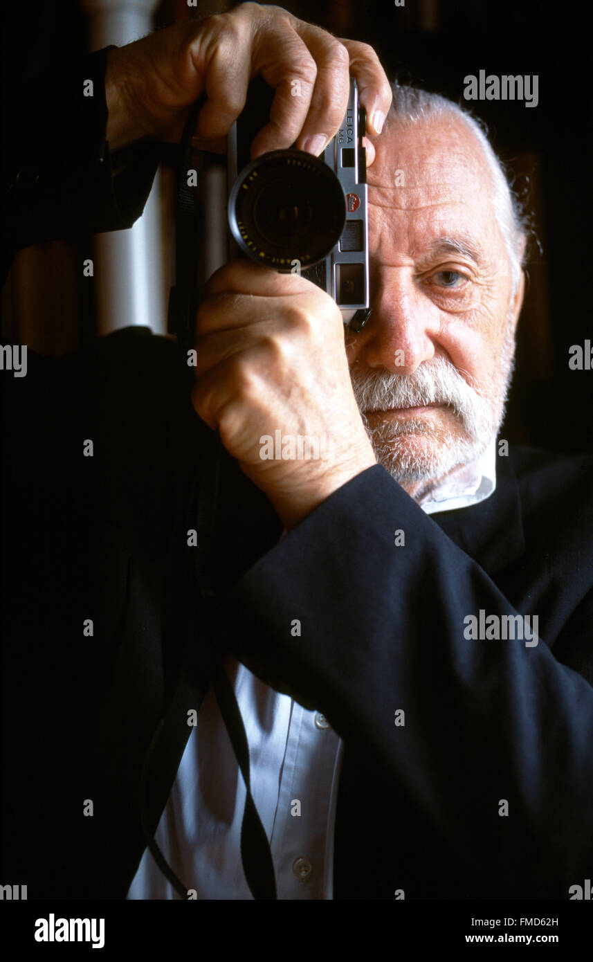 Ettore Sottsass, retrato con una cámara Leica M6 sosteniendo en sus manos Foto de stock