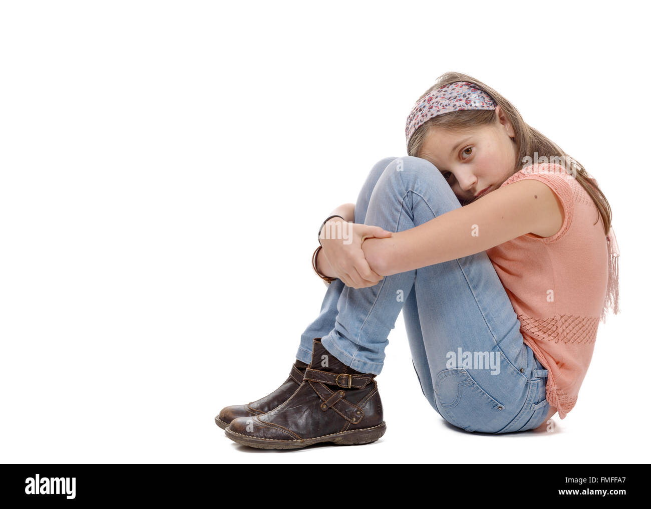Una niña preadolescentes triste está sentada en el suelo Foto de stock