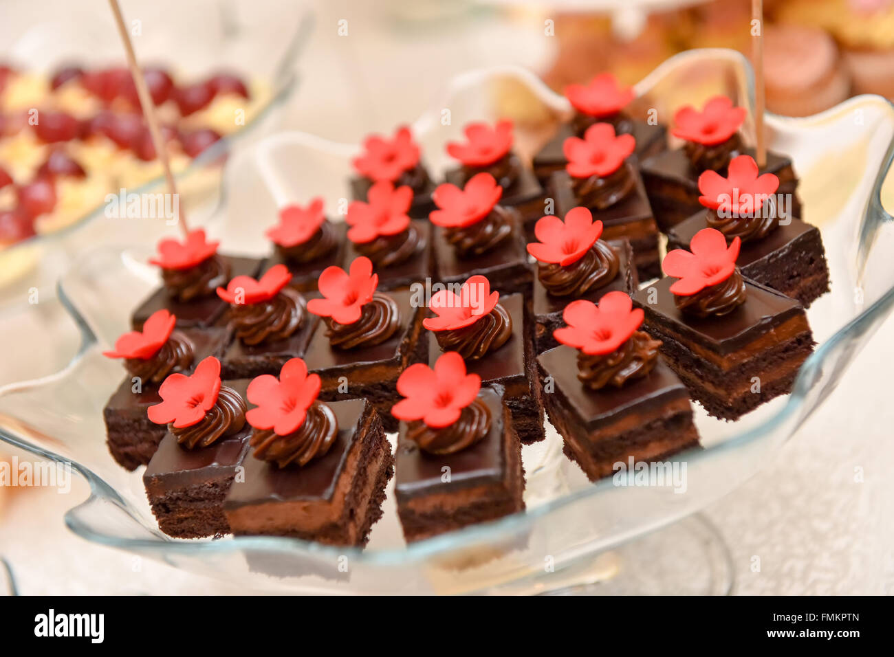 Pasteles de chocolate con flor roja que se coloca en un plato de cristal Foto de stock
