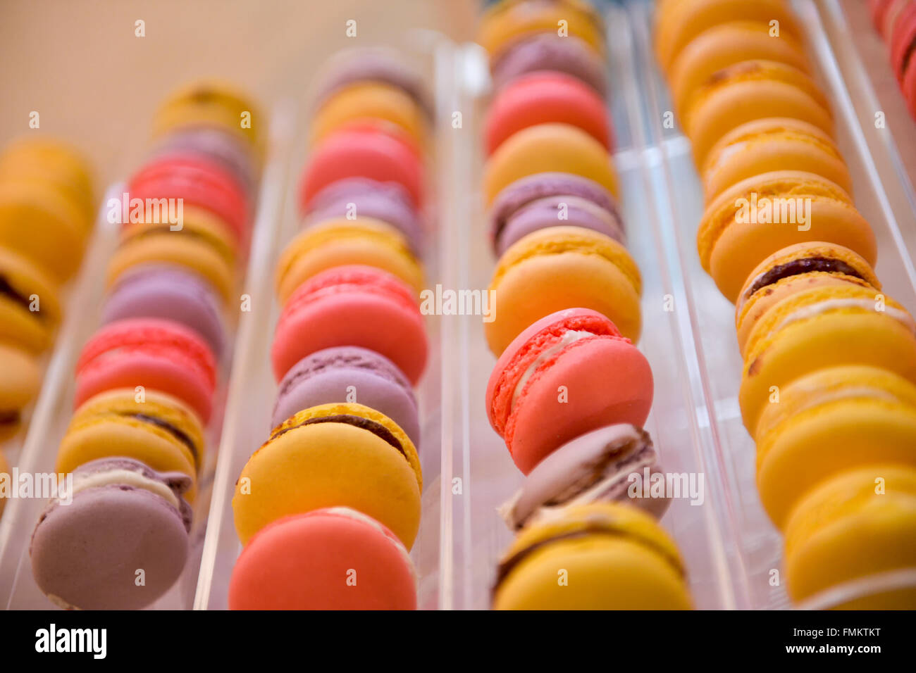 Fila de color diferente de macarons en luz natural Foto de stock