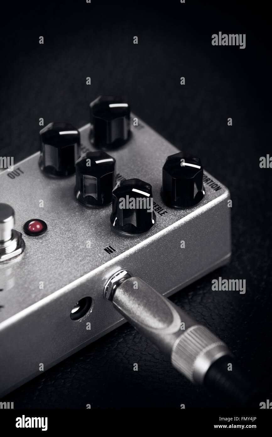 Un pedal de distorsión de guitarra sobre un fondo negro Foto de stock