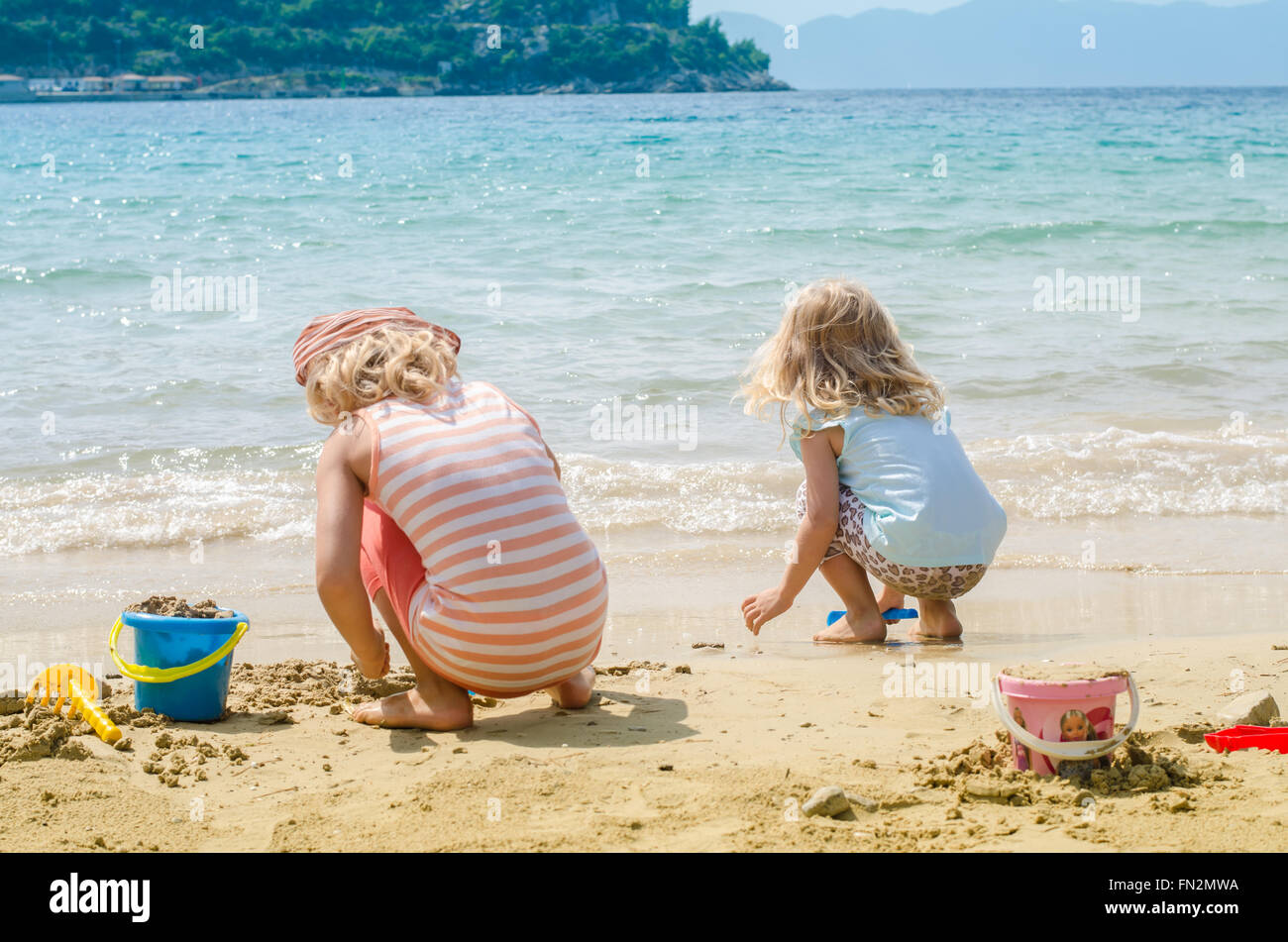 Niñas jugando en la playa con arena fotografías e imágenes de alta