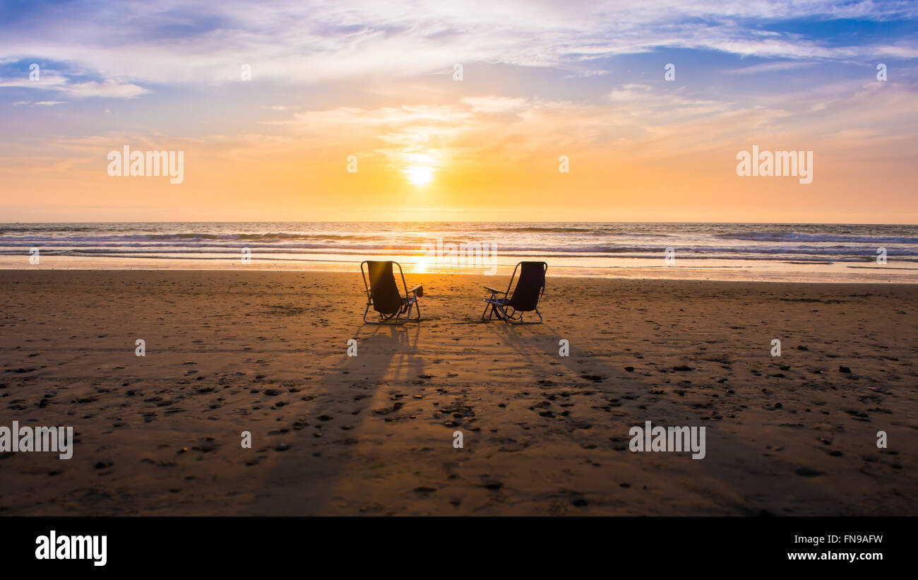Dos sillas en la playa al atardecer, California, Estados Unidos Foto de stock