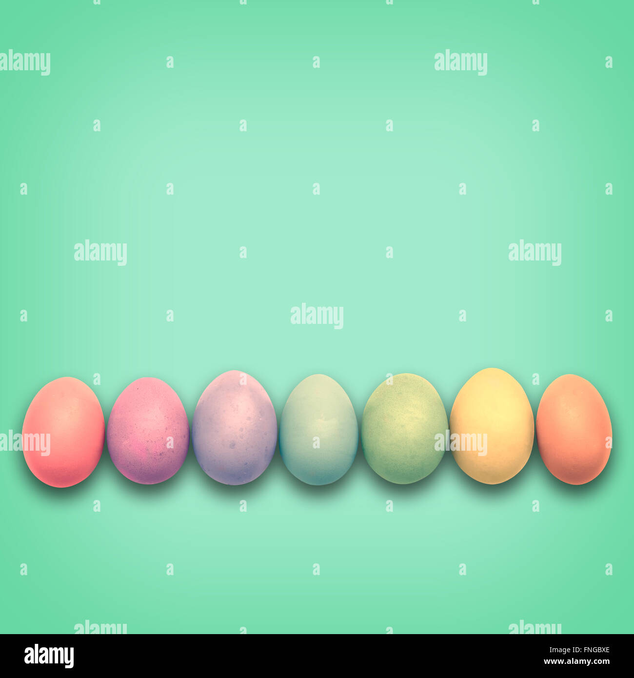 Huevos de Pascua Pastel alineadas, fondo verde Foto de stock