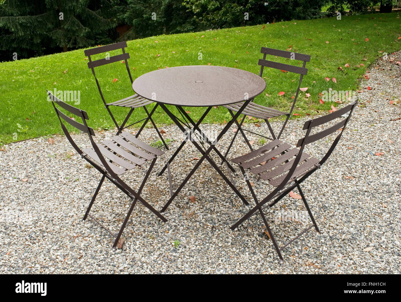 Mesa y sillas de hierro en un jardín. Foto de stock