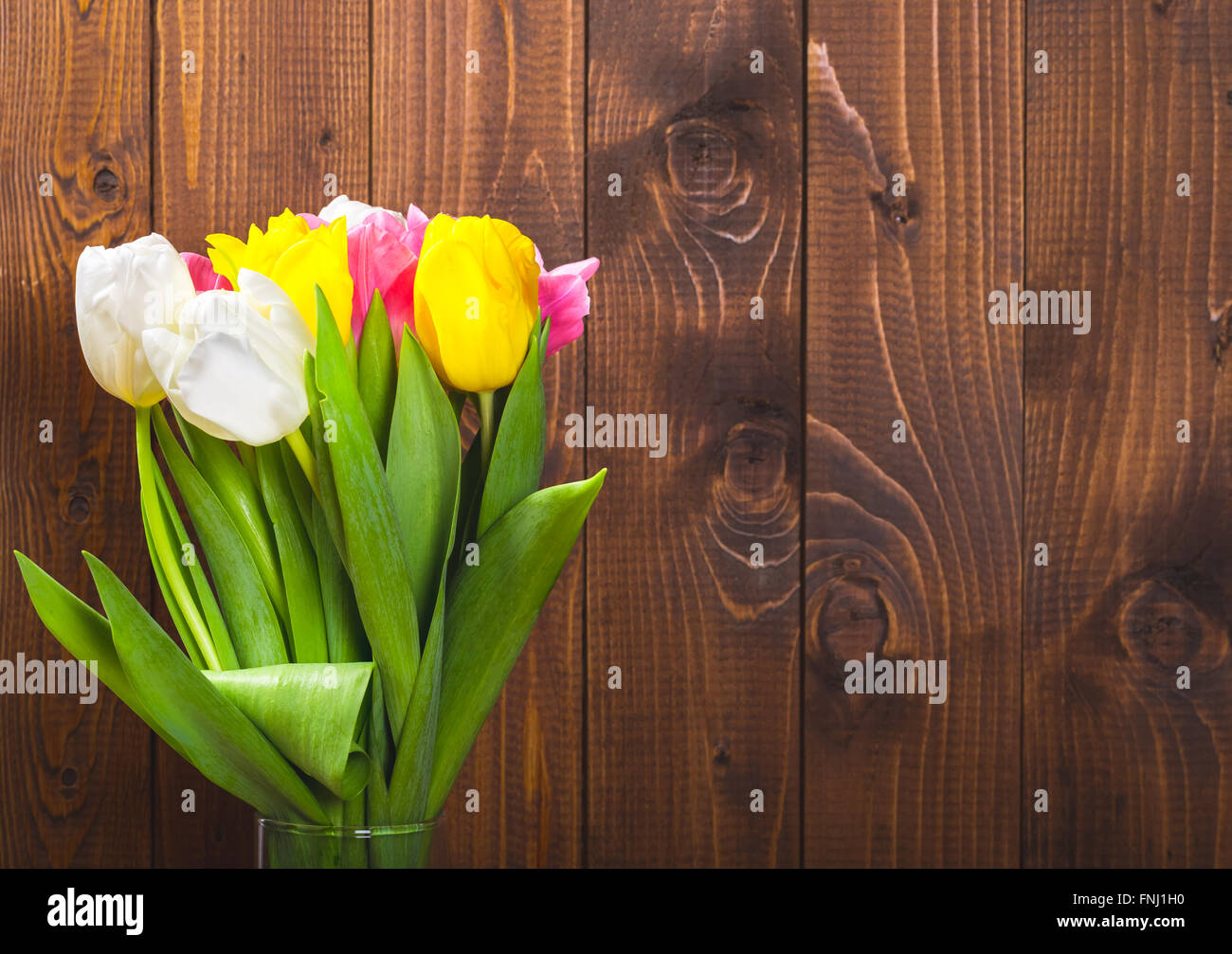 Ramo de tulipanes en frente de escena de primavera sobre el fondo de madera. un ramo de flores para el 8 de marzo, o el día de San Valentín Foto de stock
