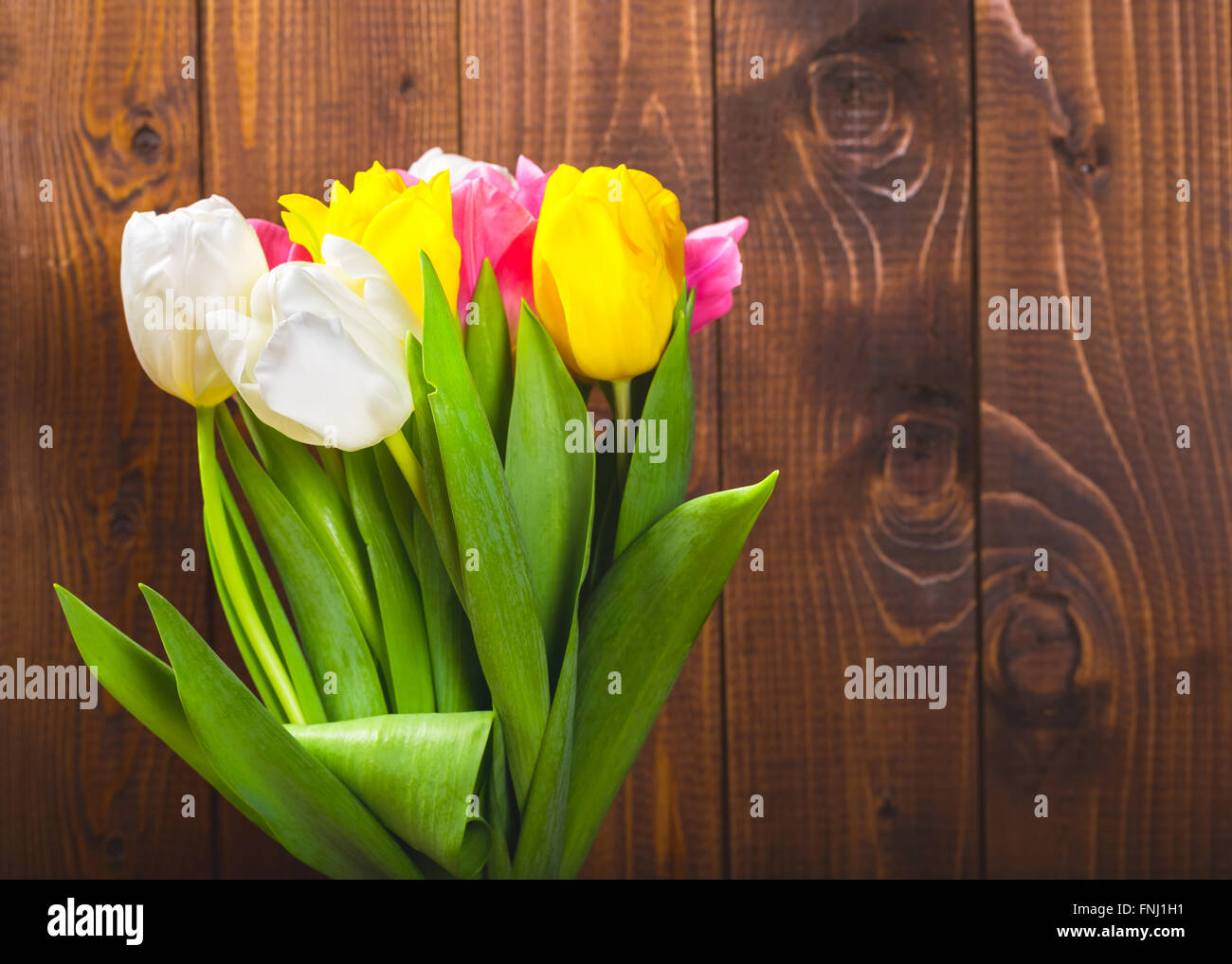 Ramo de tulipanes en frente de escena de primavera sobre el fondo de madera. un ramo de flores para el 8 de marzo, o el día de San Valentín Foto de stock