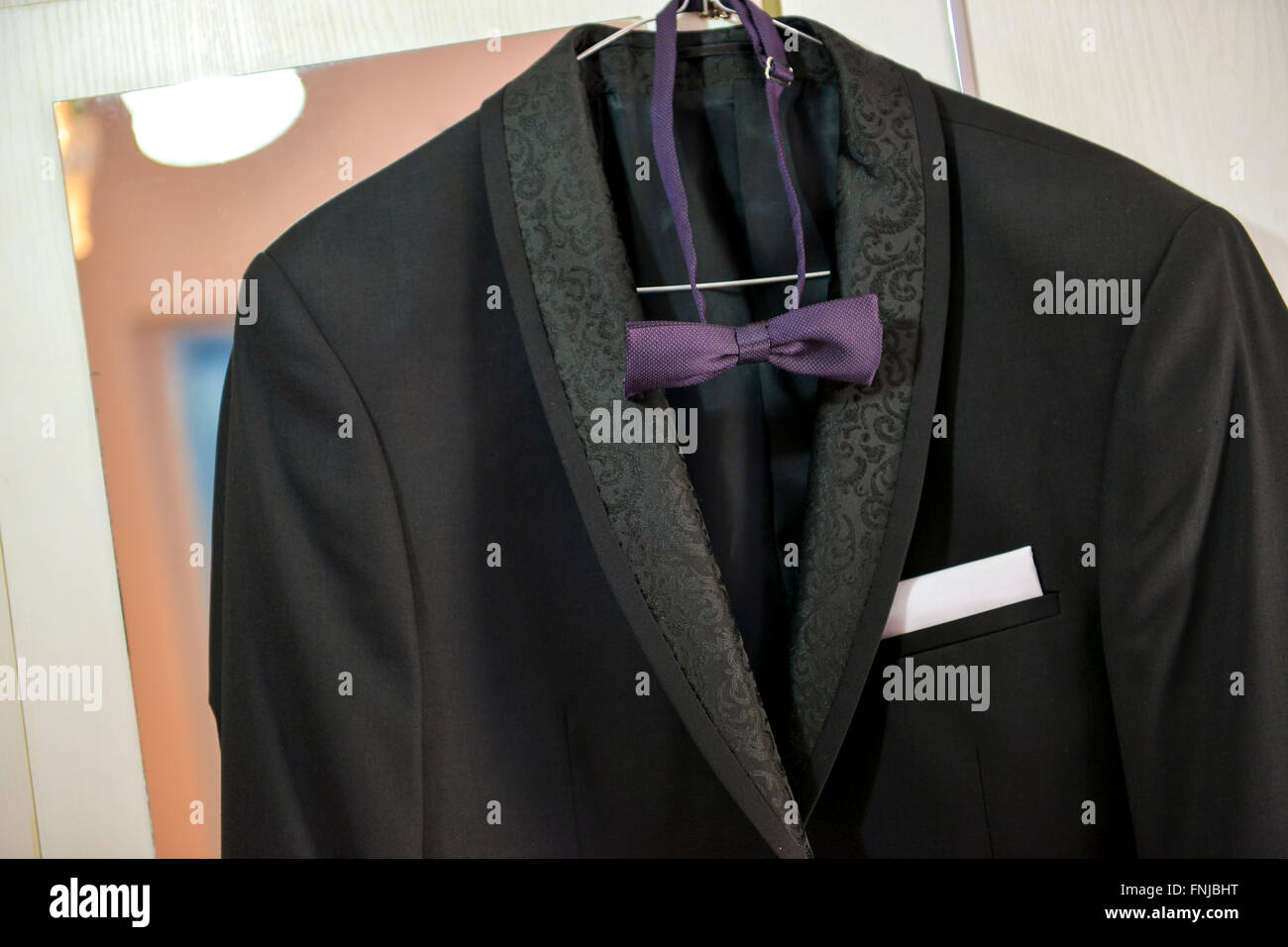 Traje negro con pajarita púrpura armario Foto de stock