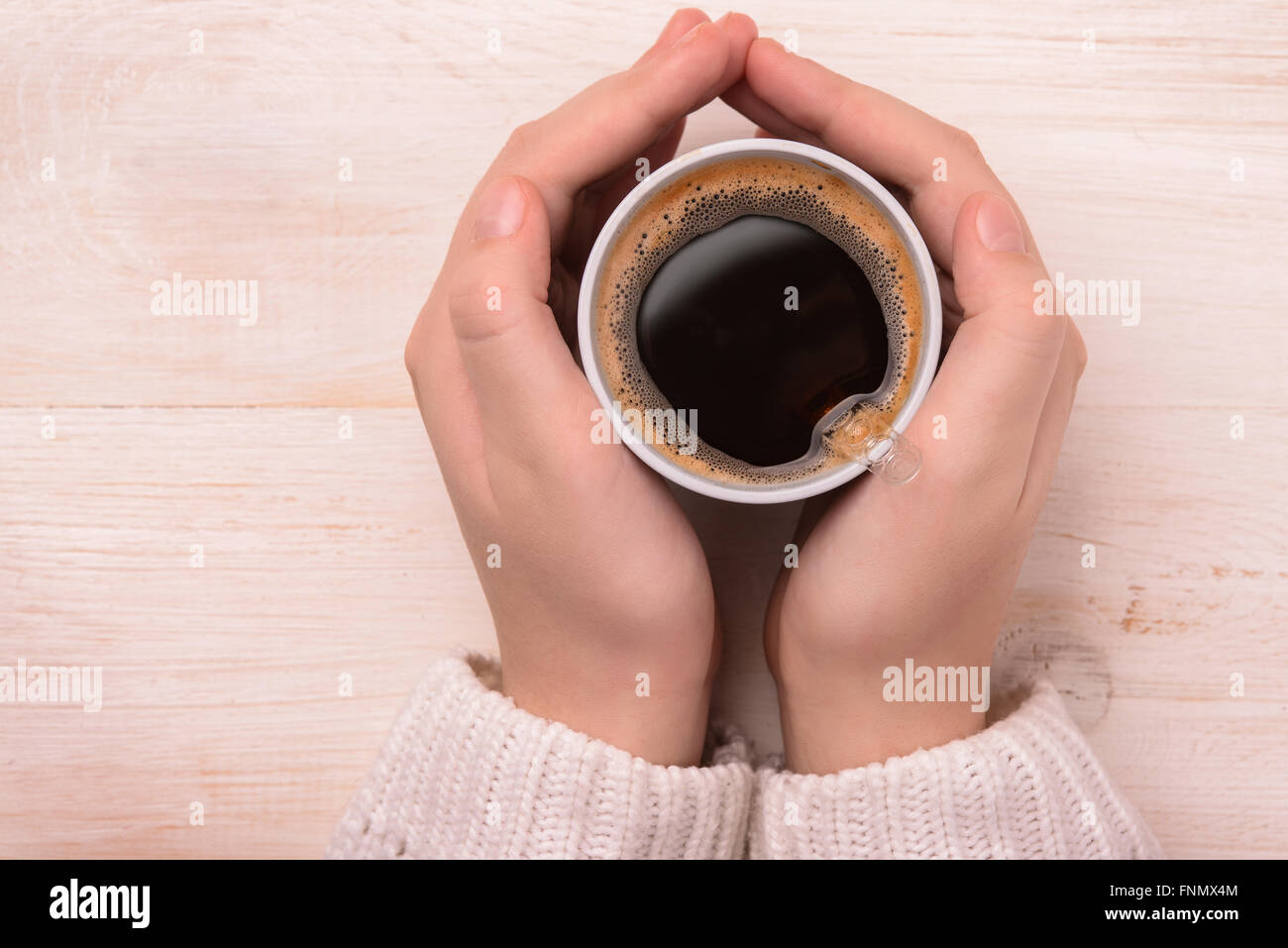 Vista superior de manos sosteniendo la taza de café de plástico Foto de stock