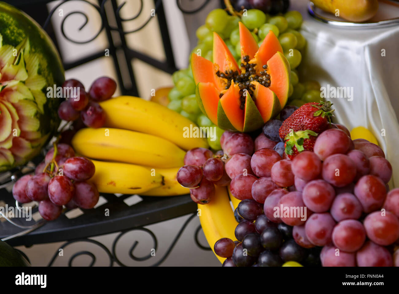 Las uvas, los plátanos, aguacates, fresas colocados sobre una mesa Foto de stock