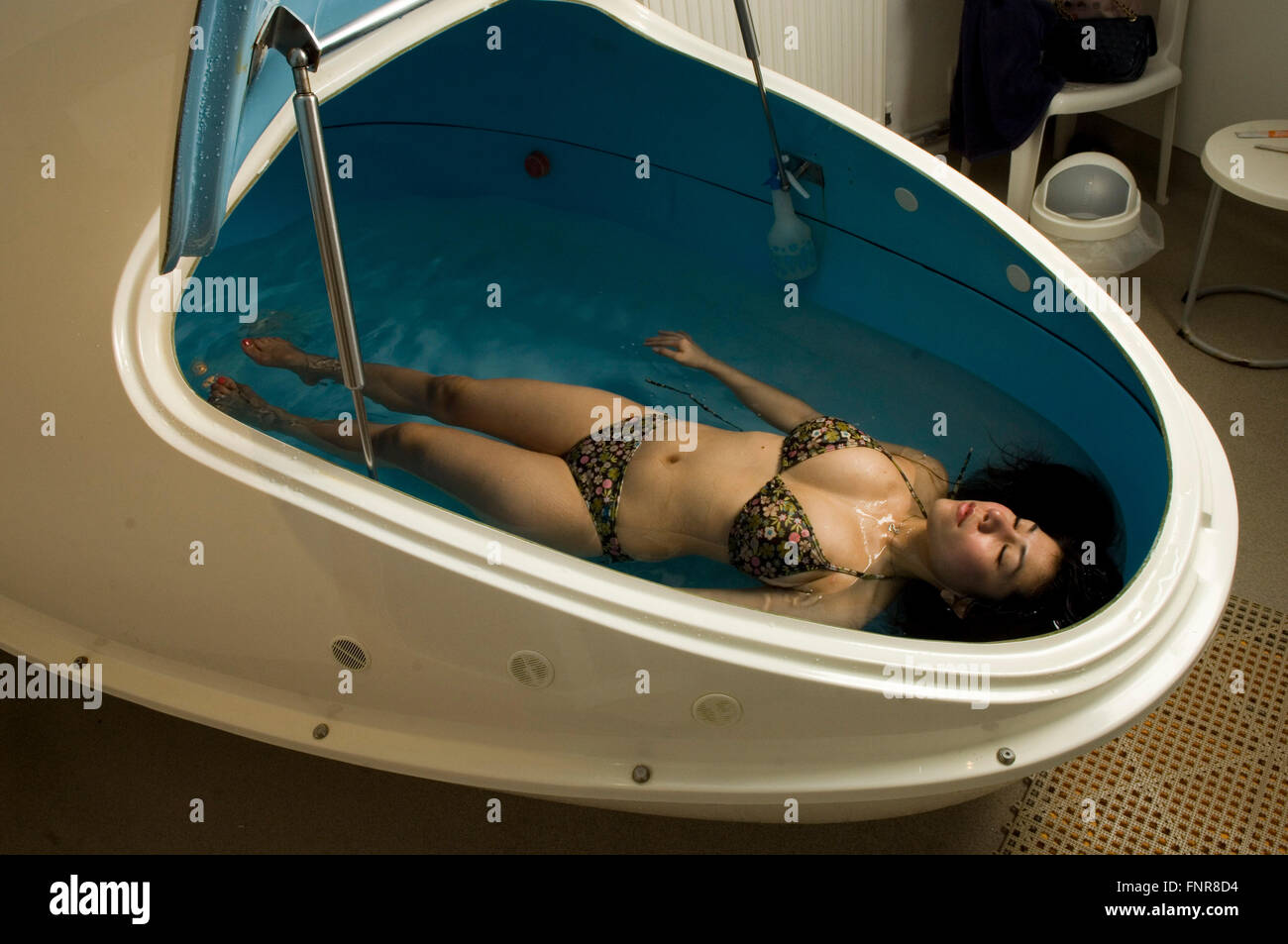 Terapia de flotación emprendida por una mujer con un tanque de flotación. Foto de stock
