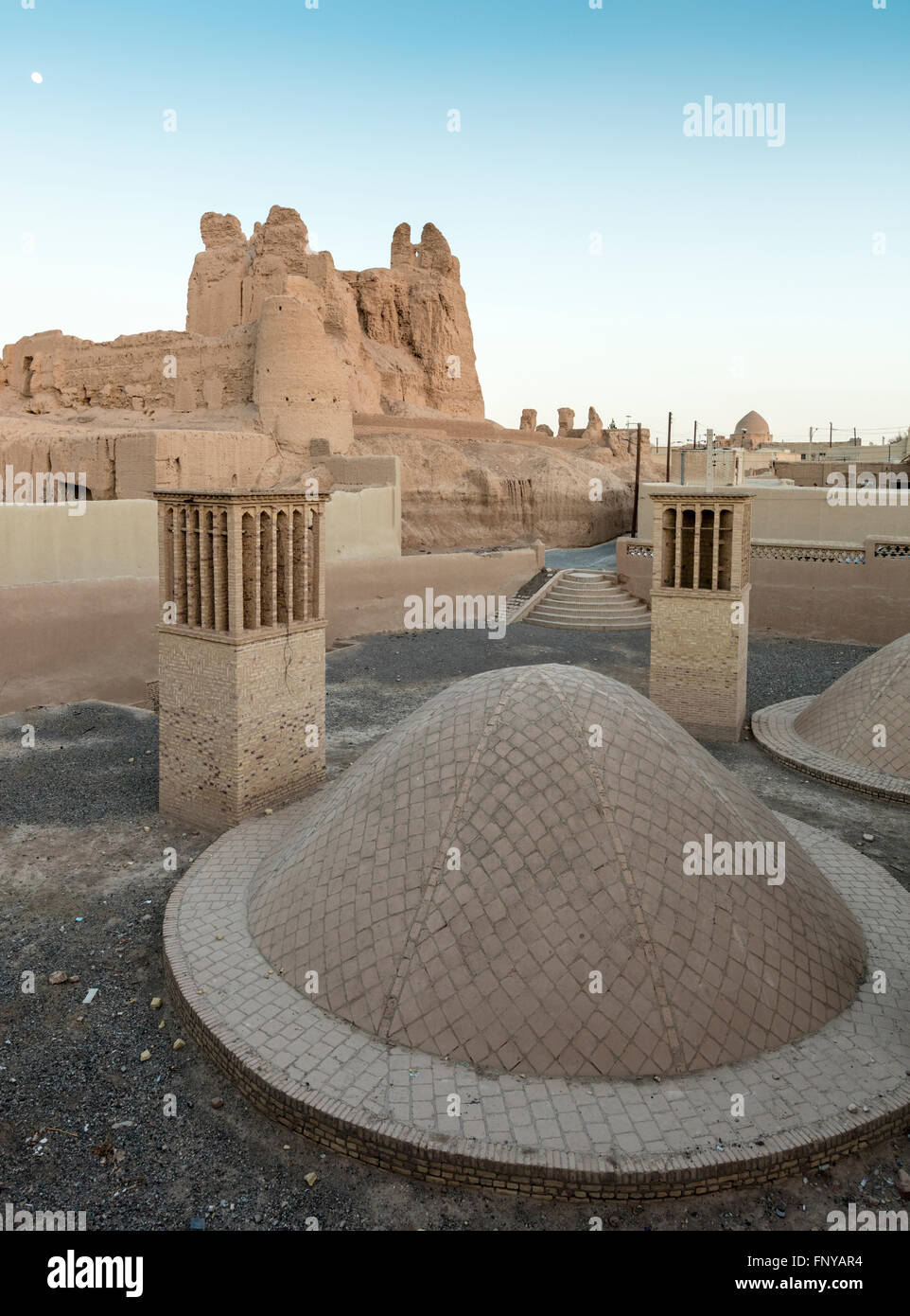 Luna sobre Nar Qale Citadel, torres eólicas, y cisternas, Naein, Irán. Las torres de viento se utilizan para enfriar el agua subterránea. Foto de stock