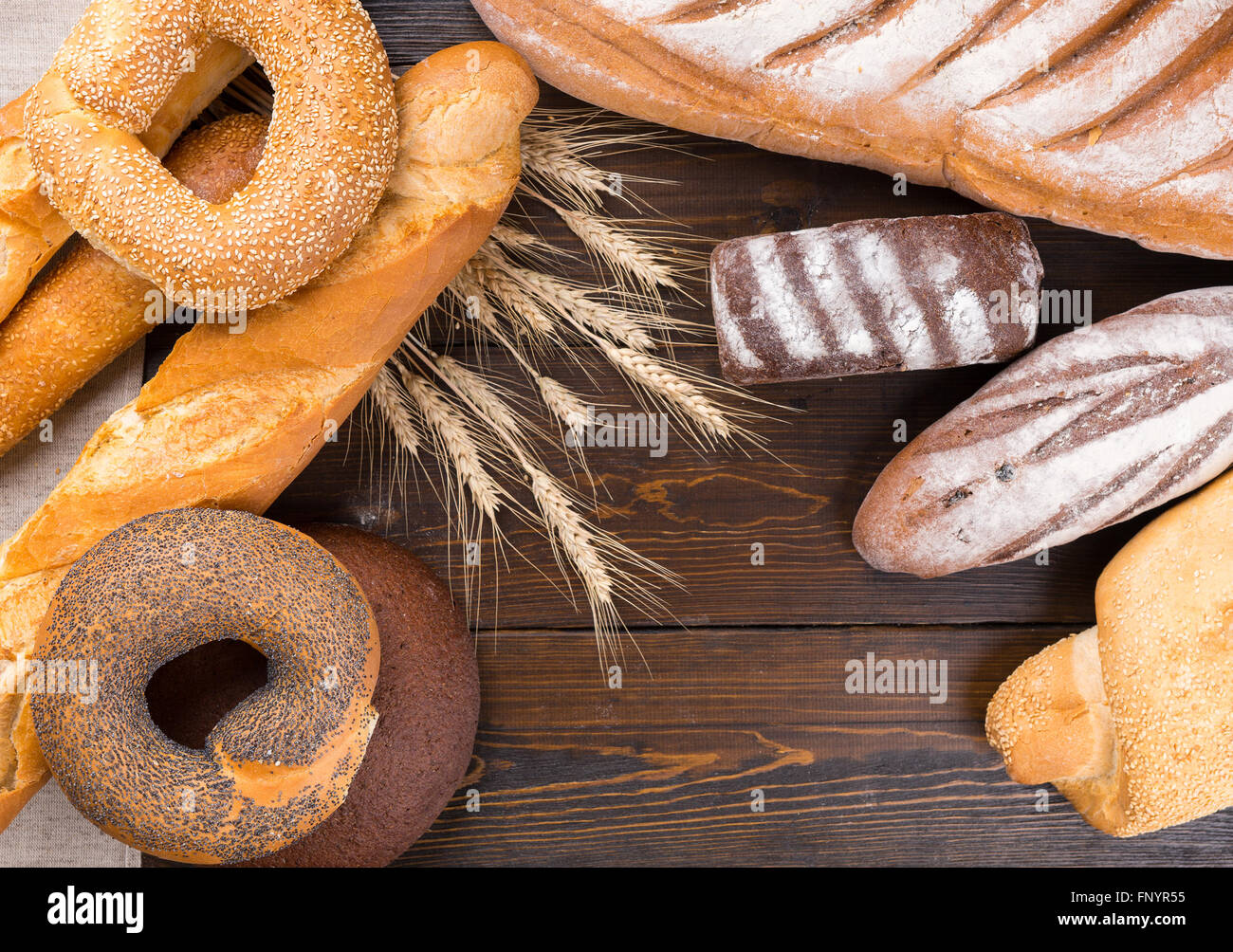 De arriba a abajo vista cercana sobre diversos tipos de panes de todo el pan  sobre la mesa de madera de caoba con espacio en el medio de copia  Fotografía de stock -
