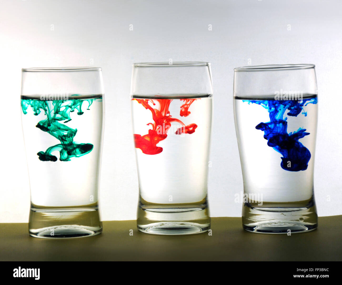 Gotas de color en el vaso de agua Foto de stock