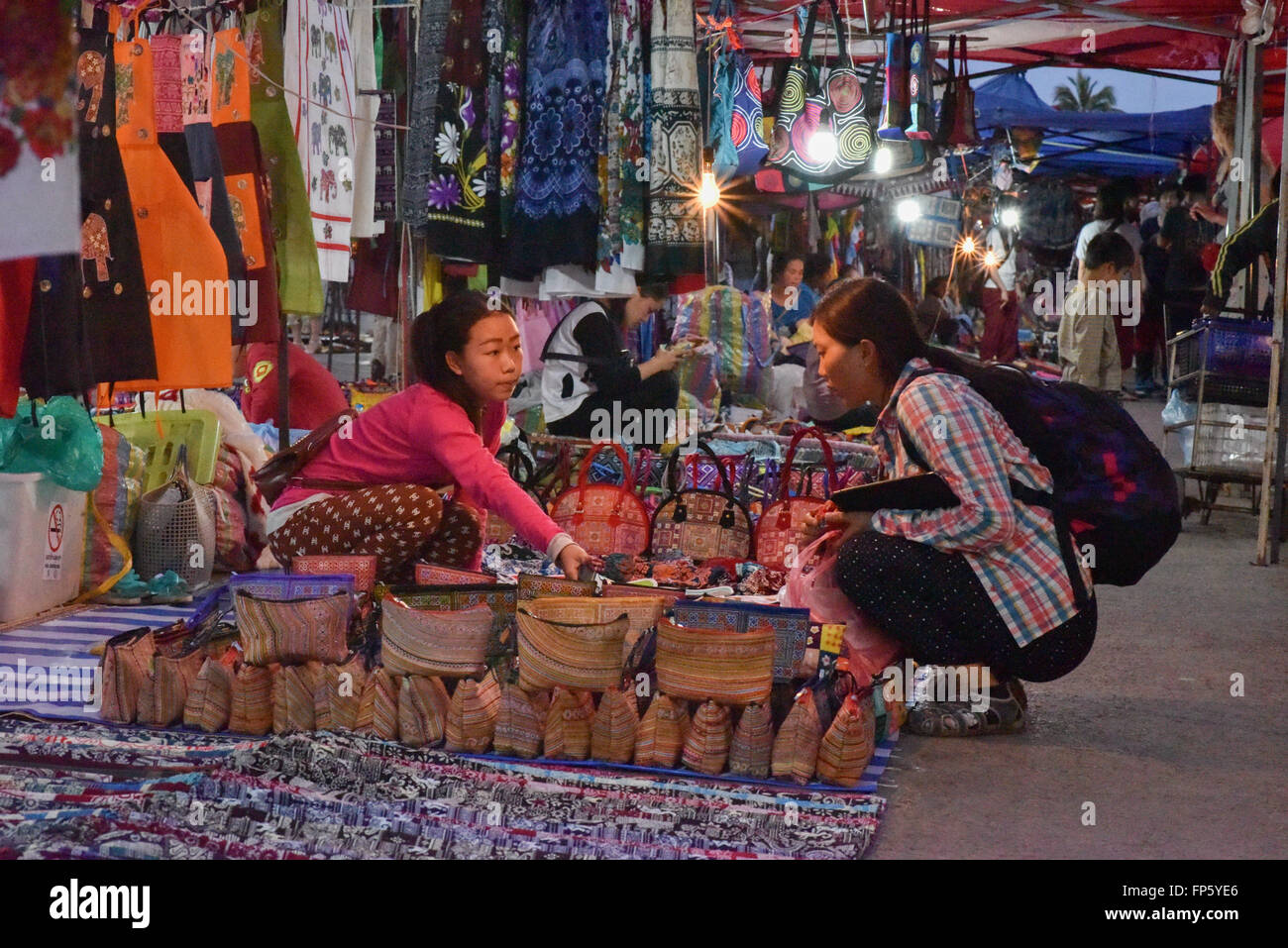 Turista hablando con el vendedor del Mercado Nocturno de Luang Prabang Foto de stock