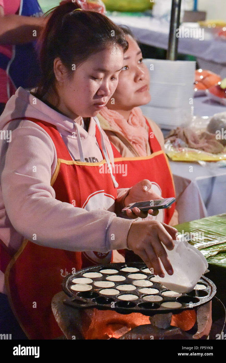 Luang Prabang, el mercado nocturno de la calle Khao nom kok, bite-sized Lao tortas de coco. Hecha con harina de arroz y crema de coco Foto de stock