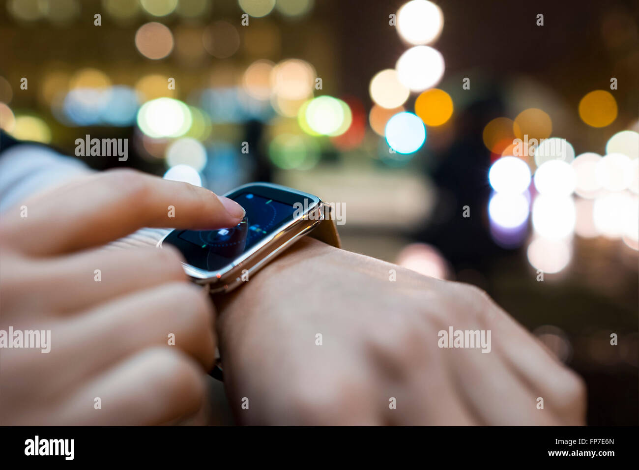 Mujer en la ciudad, con su smartwatch. Luz de noche boke antecedentes. App,sms,messga,mail Foto de stock