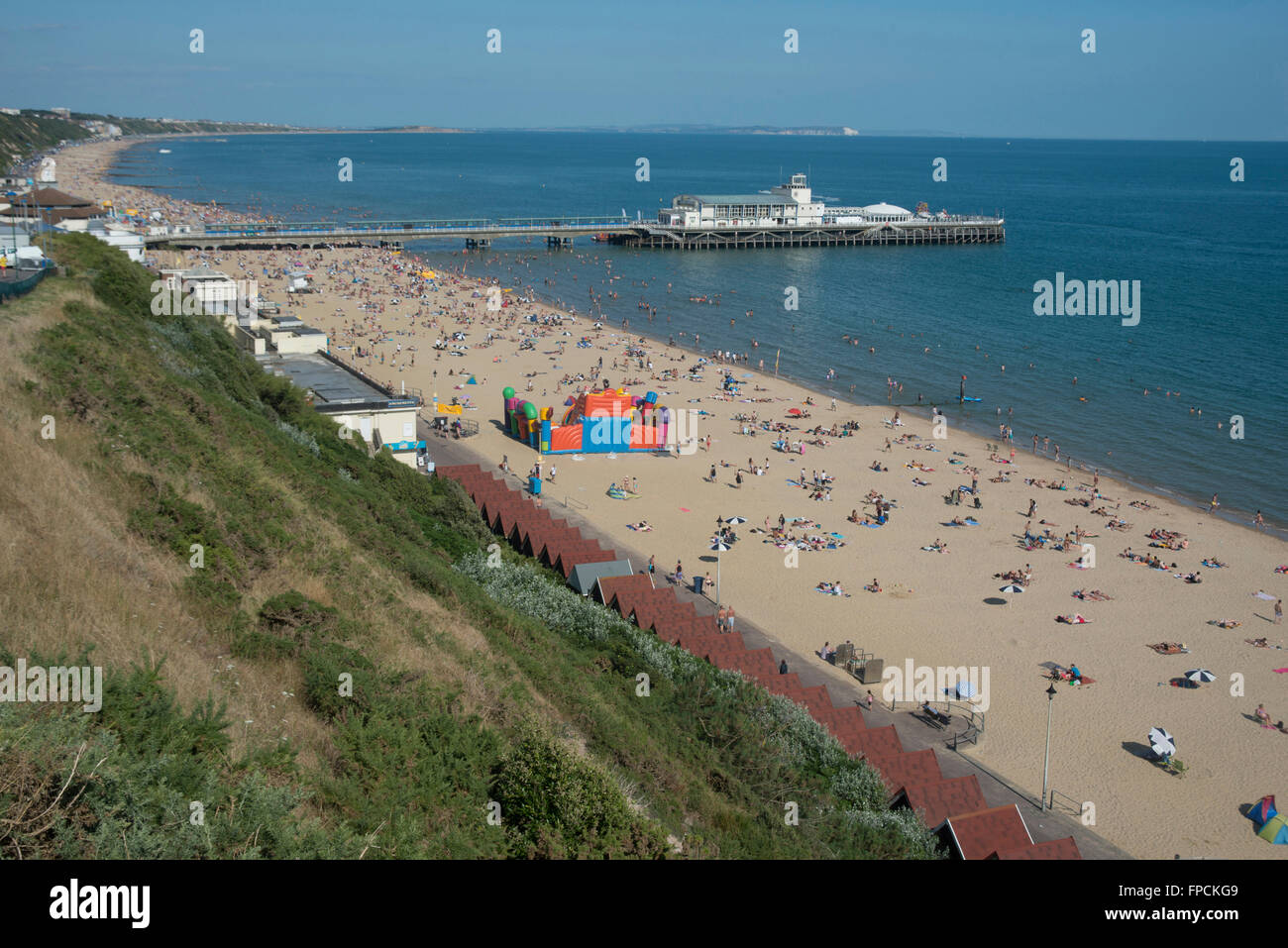 Una vista desde arriba de la playa llena de gente, el malecón puede ser visto en la distancia. Foto de stock