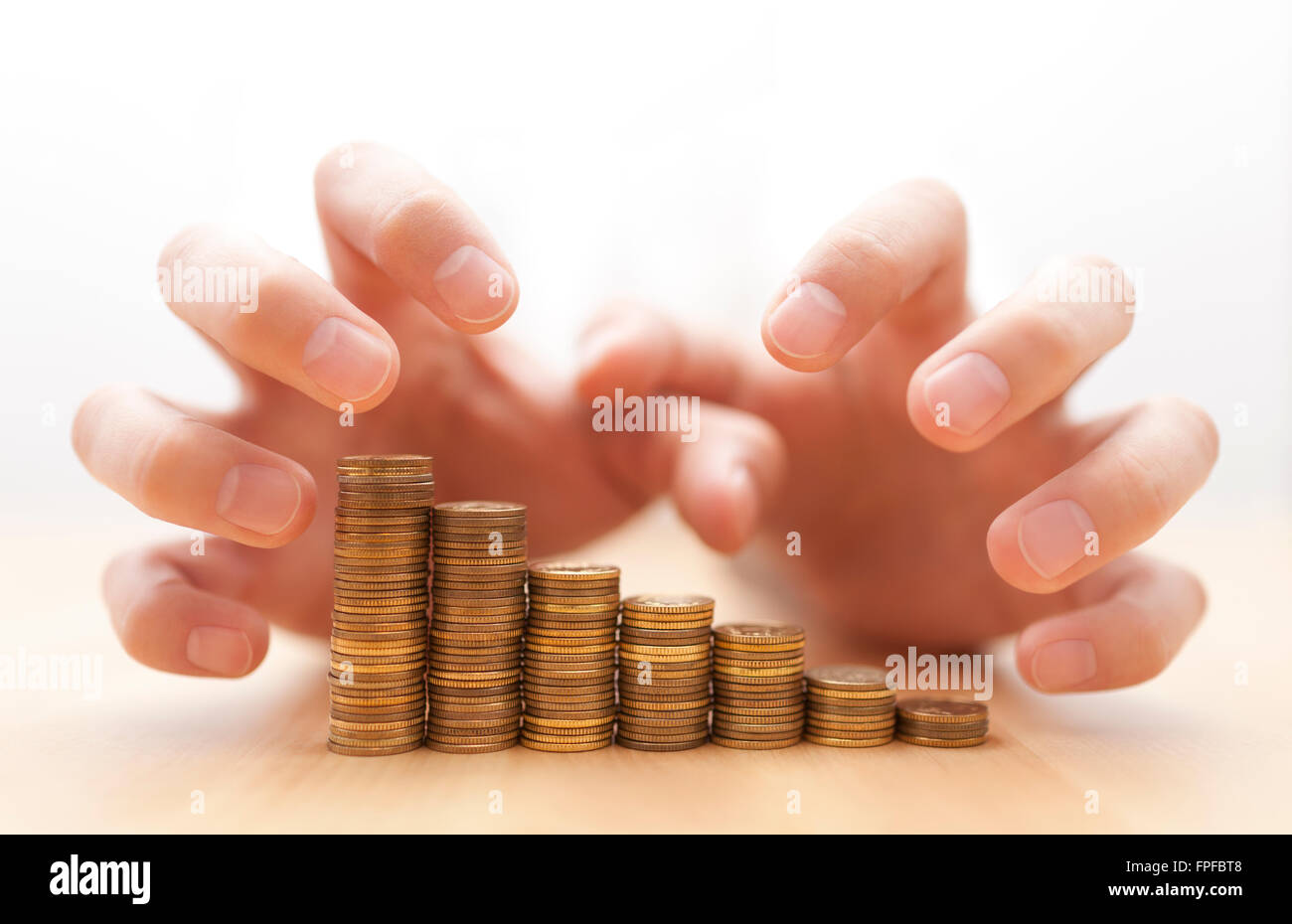 Avaricia por el dinero. Manos agarrando monedas. Foto de stock