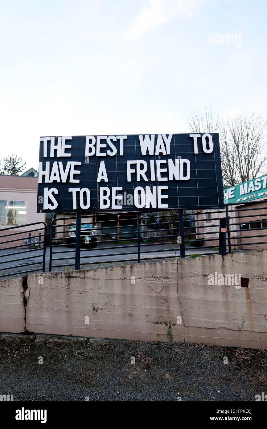 PORTLAND, OR - Febrero 27, 2016: Lector junta un letrero indica que la mejor manera de tener un amigo es ser uno. Foto de stock