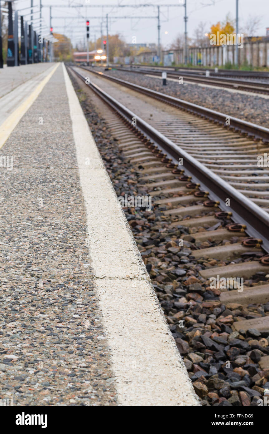 Vía férrea, plataforma y tren. Efecto de desenfoque de imagen con perspectiva decreciente Foto de stock