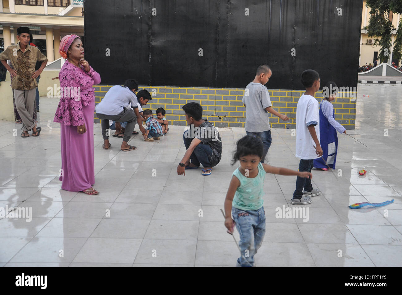 Makassar, indonesa. Los niños juegan en un espacio público. Foto de stock