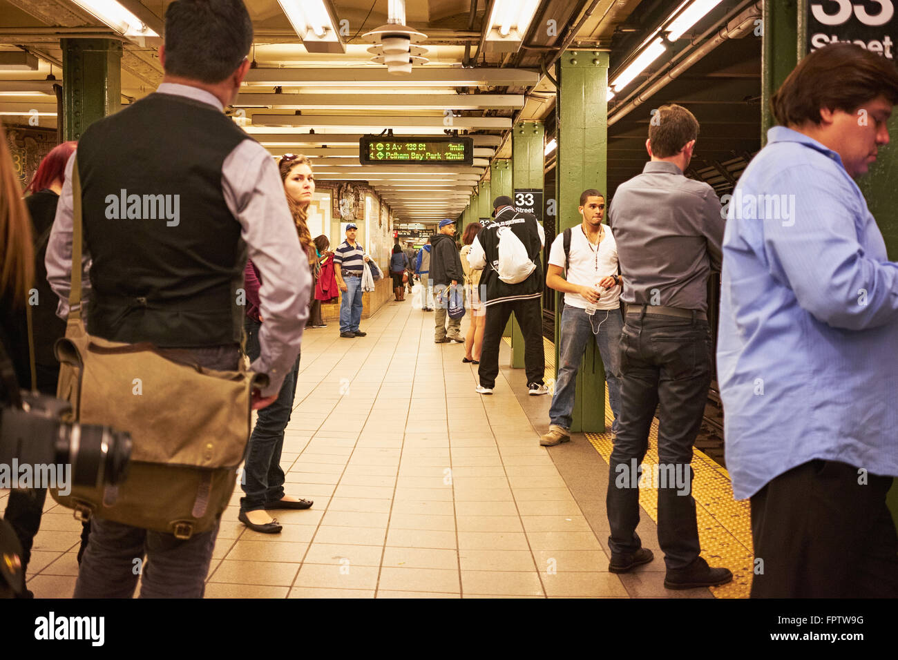 La gente esperando el tren subterráneo en la plataforma de la estación de la calle 33 Foto de stock
