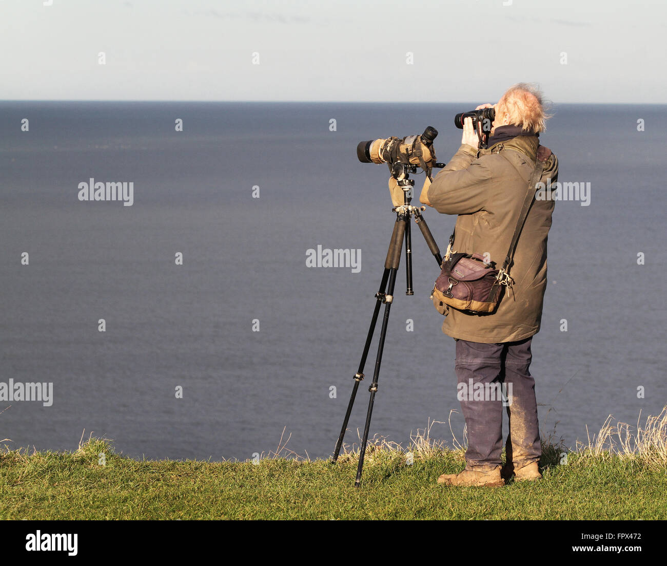 Ornitólogo con cámara y telescopio. Foto de stock