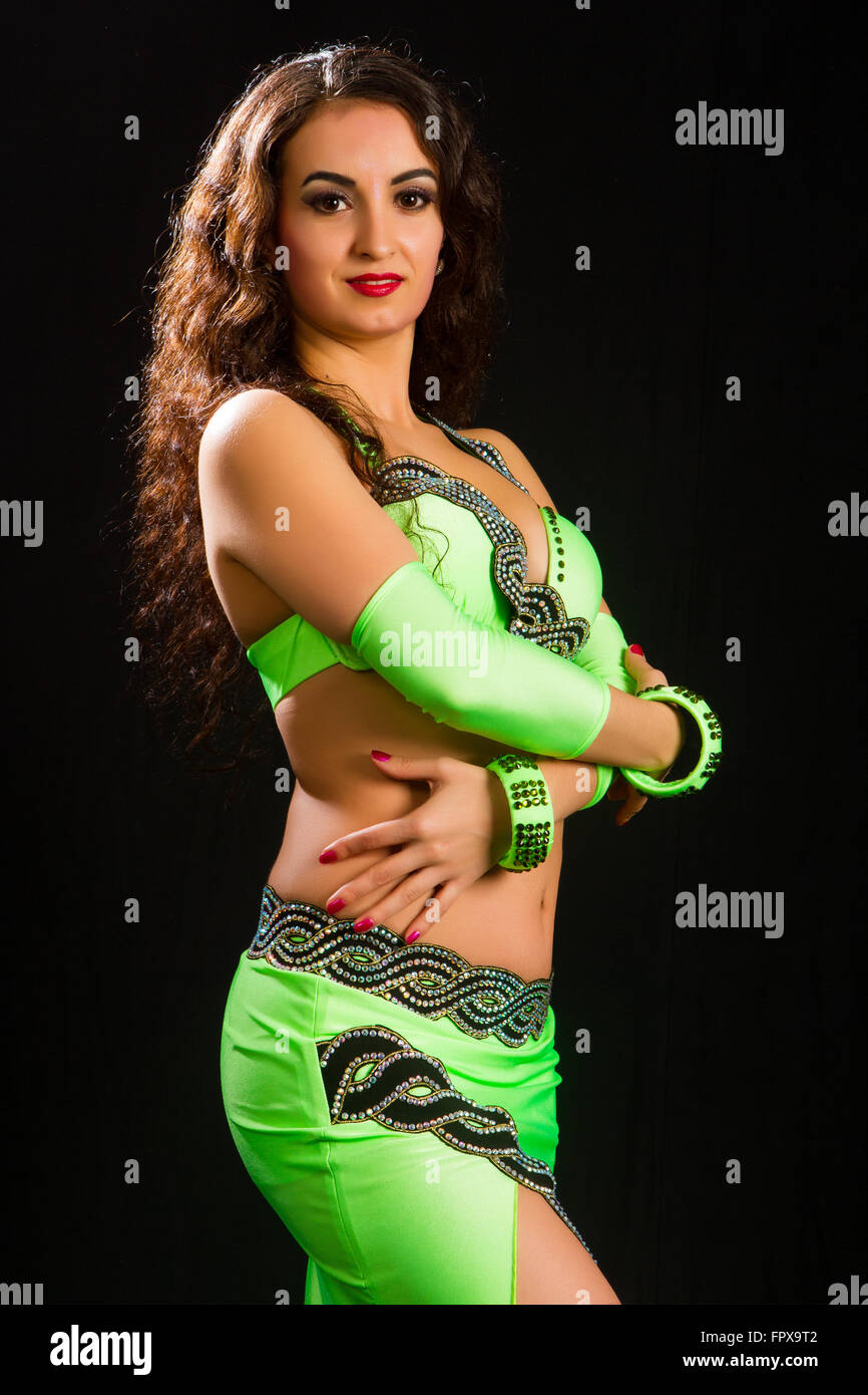 https://c8.alamy.com/compes/fpx9t2/hermosa-joven-morena-en-un-traje-verde-de-la-danza-oriental-sobre-fondo-negro-fpx9t2.jpg