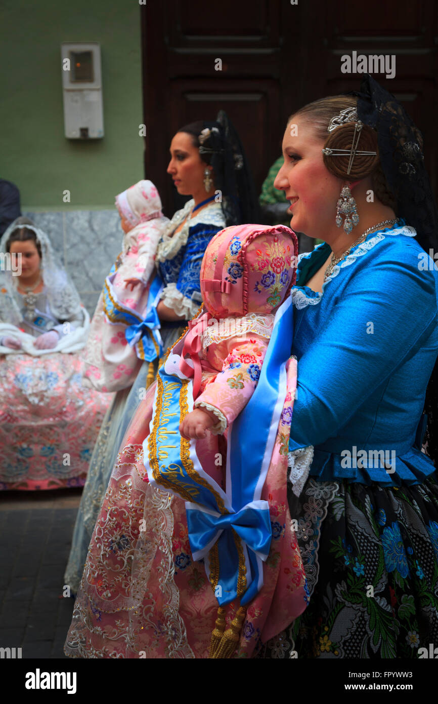Dos mujeres en traje tradicional española llevar bebés en la procesión de las Fallas en Gandia España Foto de stock