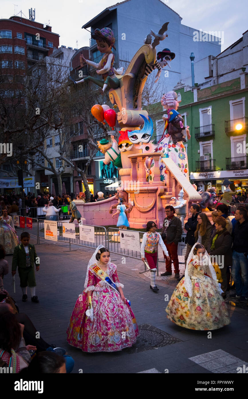 Dos niñas en traje tradicional española en las Fallas procesión pasando uno de las efigies Foto de stock