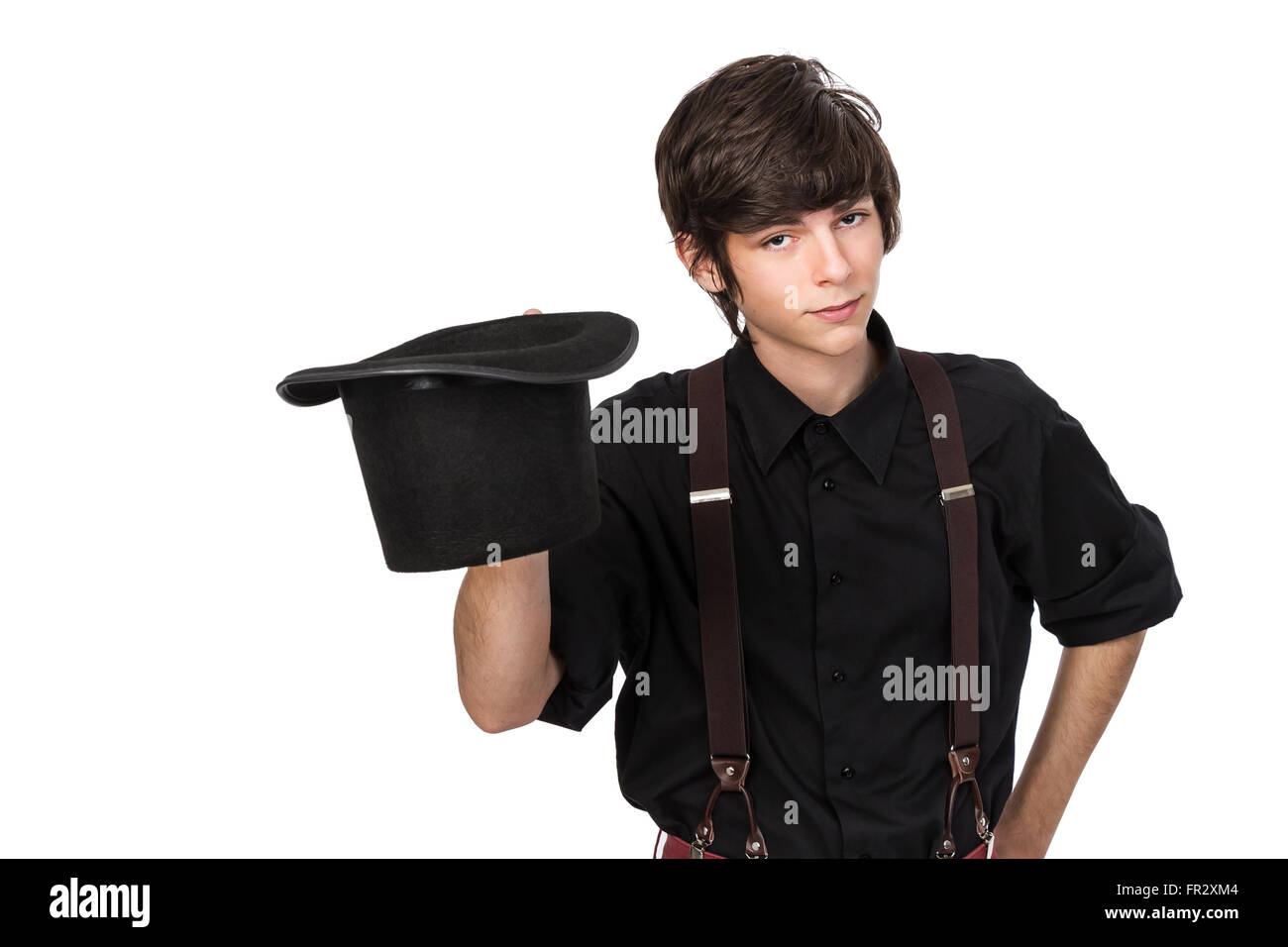 Atractiva joven macho en una camisa negra y jeans tirantes, sosteniendo un  sombrero negro en un sombrero salute, con confianza y inqui Fotografía de  stock - Alamy