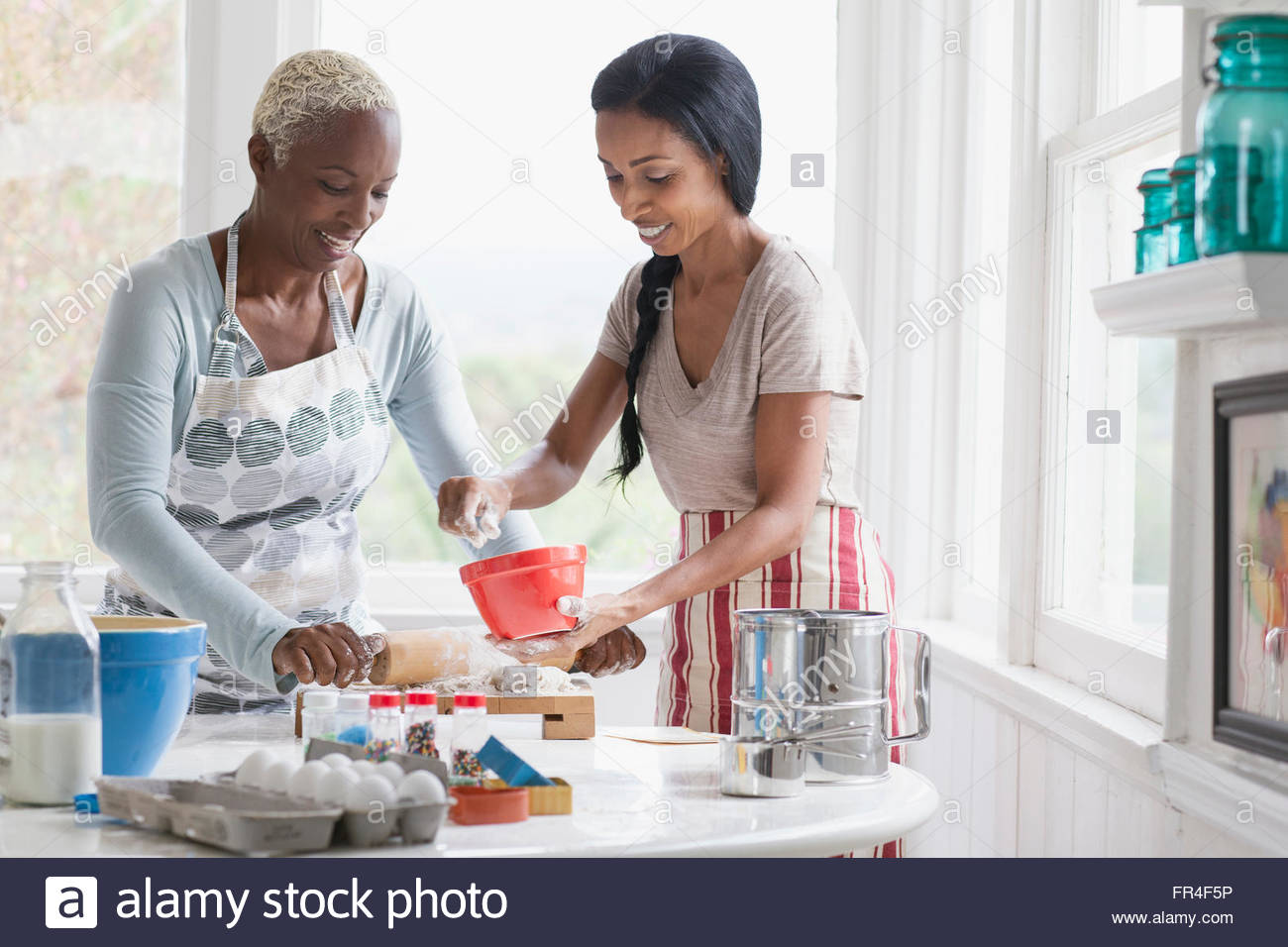 Madre e hija adulta haciendo productos horneados Foto de stock