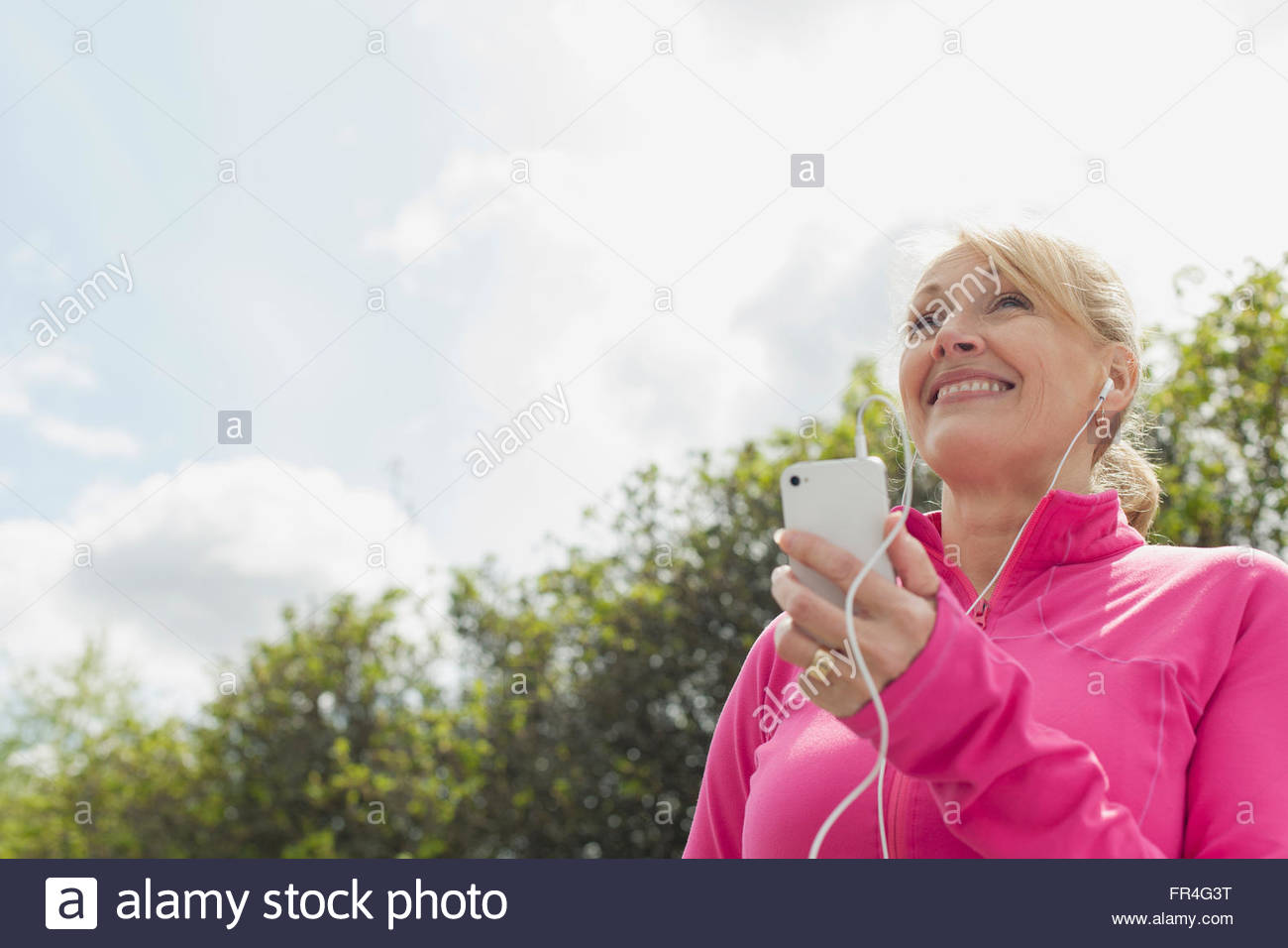 Senior mujer escuchando música en el smartphone Foto de stock