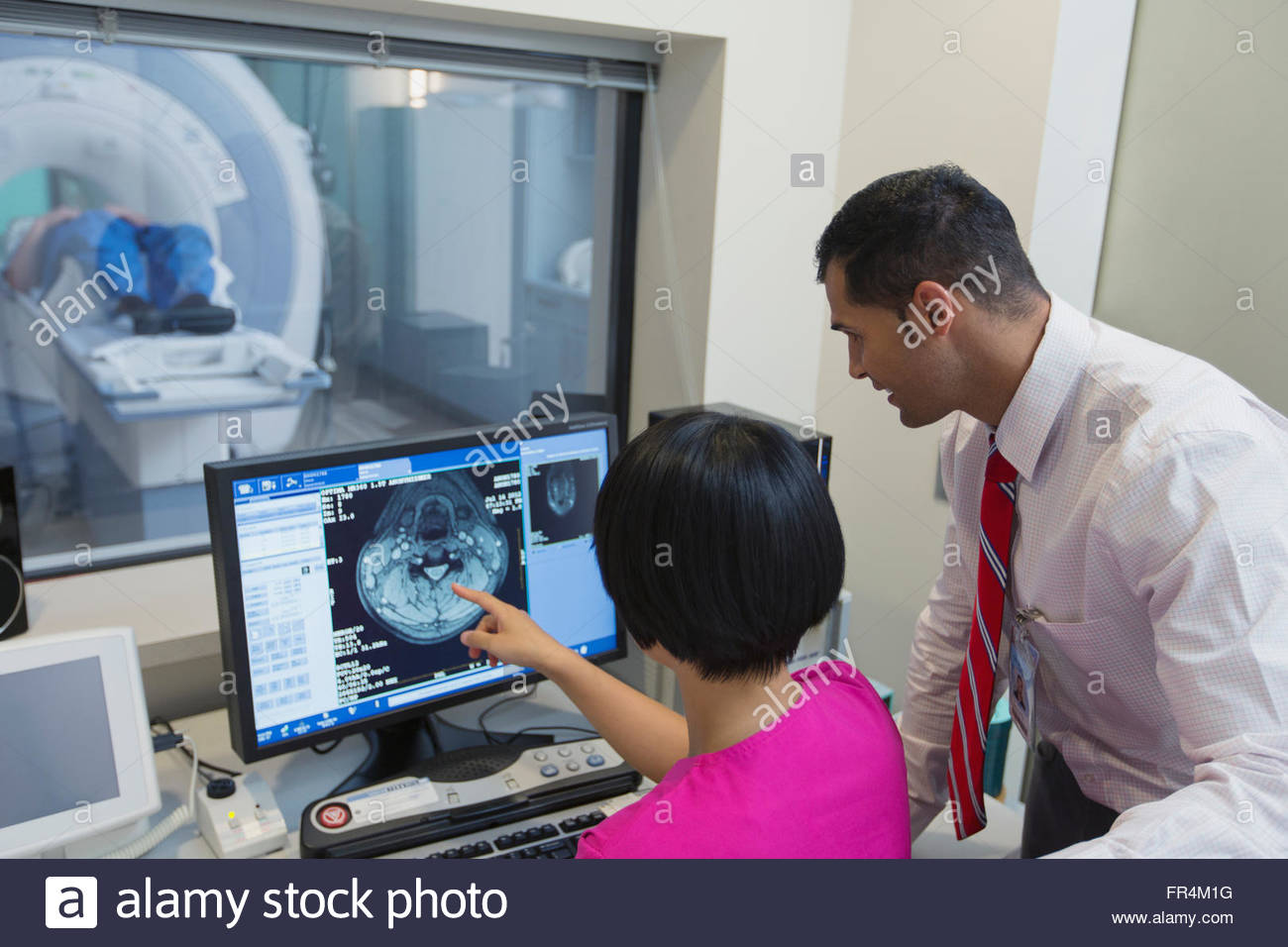 Médico y Técnico hablando de imágenes de escáner de RM Foto de stock