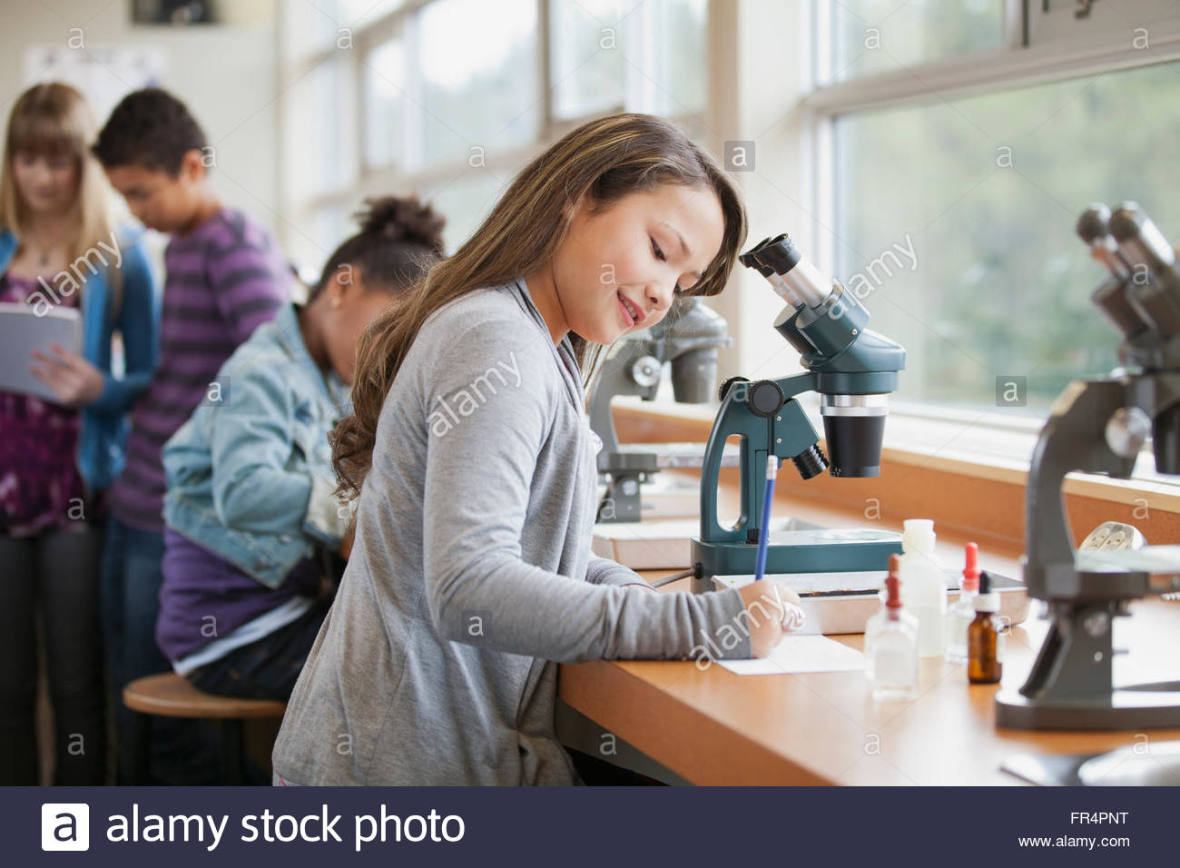 Los estudiantes de escuela intermedia con microscopios Foto de stock