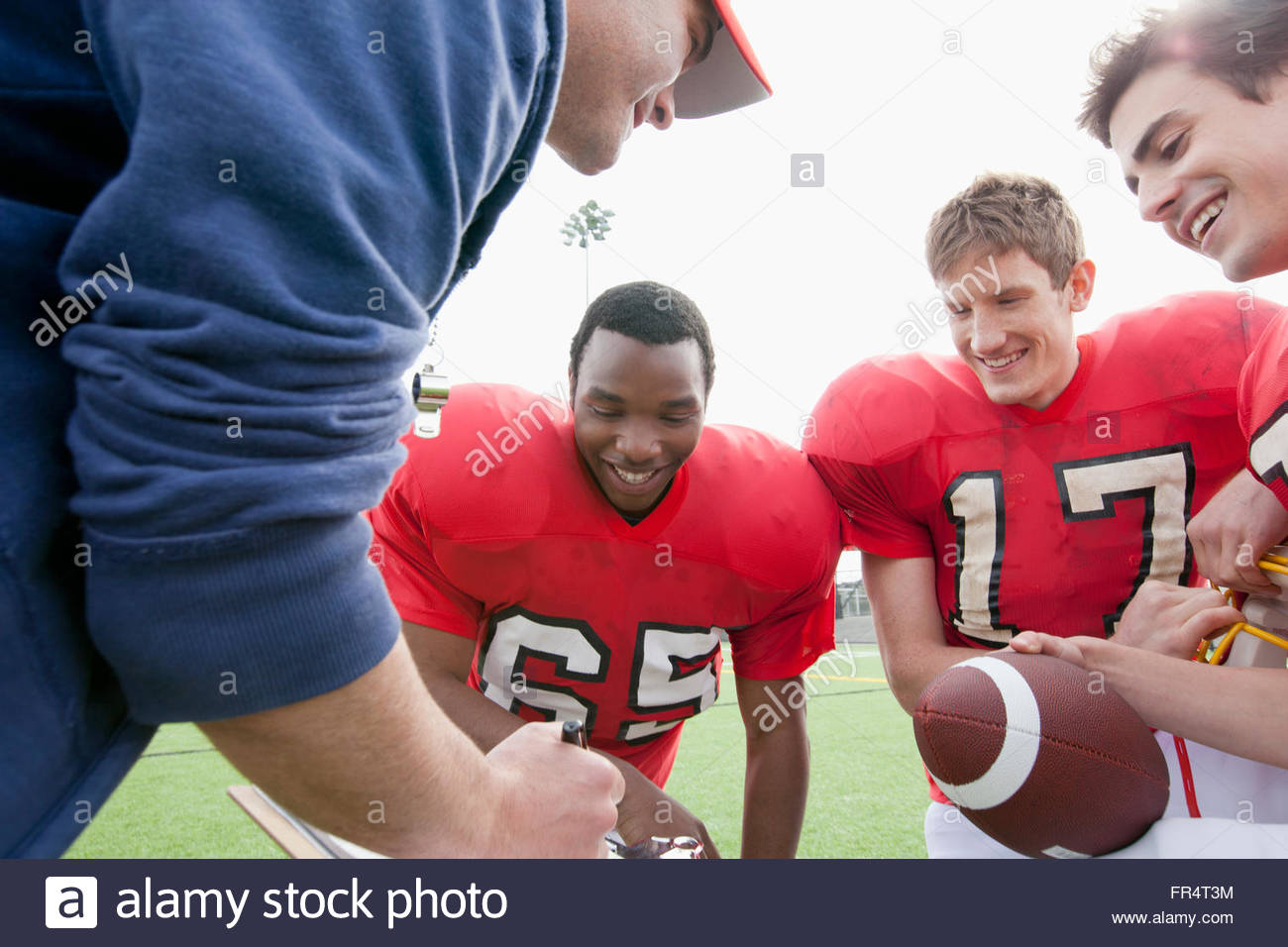Autobús hablando con los jugadores de fútbol americano universitario Foto de stock