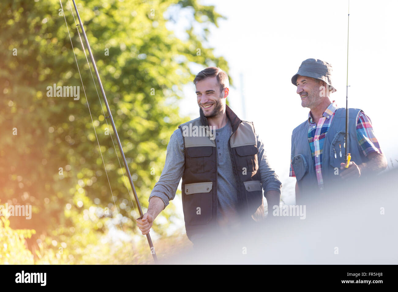 Padre e hijo adulto con cañas de pescar Foto de stock
